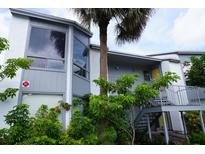 Two-story condo with palm tree, staircase entry, and ample greenery at 4378 Aqua Vista Dr # L, Orlando, FL 32839