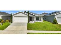 Charming single-story home featuring a well-manicured lawn and a two car garage at 4501 Hummingbird Ln, Haines City, FL 33844