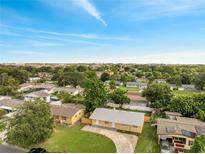An aerial view of a charming neighborhood featuring well-maintained homes and lush greenery under a blue sky at 4521 Alrix Dr, Orlando, FL 32839