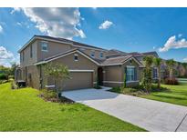 Stunning two-story home with a manicured lawn, a two-car garage, and a paved driveway at 5231 Wildwood Way, Davenport, FL 33837