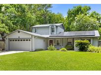 Charming home featuring solar panels, a well-maintained lawn, and lush landscaping, enhancing curb appeal at 878 Elgin Dr, Winter Springs, FL 32708