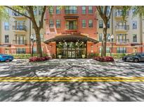 Elegant condo building entrance featuring modern glass doors, landscaping, and clear signage for Uptown Place at 911 N Orange Ave # 321, Orlando, FL 32801