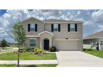 Charming two-story home with a well-maintained lawn, two car garage and black window shutters at 1343 Lassen St, Haines City, FL 33844