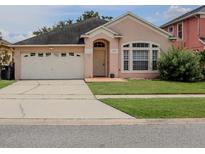 Charming single-story home featuring a well-manicured lawn and a two-car garage at 1730 Sir John Ct, Orlando, FL 32837