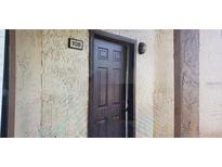 Unit 108 features a solid wood front door with a textured exterior wall and sconce lighting at 2002 Cascades Blvd # 108, Kissimmee, FL 34741