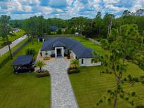 Stunning aerial view of a luxury home with a long driveway, lush landscaping, and a private setting at 20414 Quinn St, Orlando, FL 32833