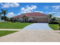 Charming single-story home features a red roof, two-car garage, manicured lawn, and mature landscaping at 2357 Great Harbor Dr, Kissimmee, FL 34746