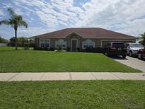 Charming single-story home with a well-maintained lawn and lush landscaping at 2357 Great Harbor Dr, Kissimmee, FL 34746