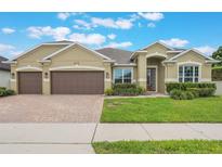 Charming, single-story home featuring a two-car garage and lush landscaping at 3212 Preserve Dr, Orlando, FL 32824