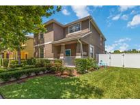 Charming two-story home with manicured lawn, inviting front porch, and white picket fence at 3221 Bayflower Ave, Harmony, FL 34773