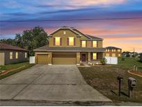 Charming two-story home with a spacious driveway and colorful sunset backdrop at 355 Churchill Ct, Kissimmee, FL 34759