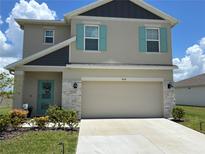 Charming two-story home featuring turquoise shutters, stone accents, and a well-manicured lawn at 464 Talisi Loop, St Cloud, FL 34771