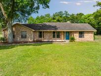 Charming single-story brick home with a well-maintained lawn and a welcoming front porch and bright blue front door at 6441 Nightwind Cir, Orlando, FL 32818