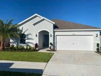 Charming single-story home with a well-manicured lawn and a two-car garage on a sunny day at 820 Cambridge Dr, Winter Haven, FL 33881