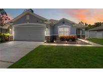 Charming single Gathering home with a well-manicured lawn and beautiful landscaping at dusk at 832 Seneca Trl, St Cloud, FL 34772