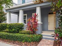 Charming front porch featuring elegant columns, manicured landscaping, and a welcoming entrance at 8359 Lookout Pointe Dr, Windermere, FL 34786