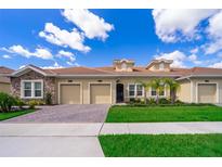 Charming home featuring a tile roof, two-car garage, and manicured landscaping at 1173 Trappers Trail Loop, Champions Gate, FL 33896