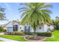 Charming single-story home with a well-manicured lawn, lush landscaping, and inviting curb appeal at 125 Prima Dr, Poinciana, FL 34759
