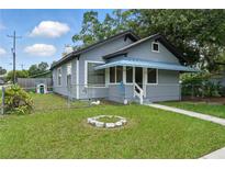 Charming gray home featuring a well-maintained front yard and a blue-covered porch at 1322 New York Ave, St Cloud, FL 34769