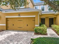Charming townhome featuring a two-car garage, brick-paved driveway, and double front doors at 14234 Desert Haven St # 14234, Windermere, FL 34786