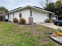 Charming home featuring a two-car garage, decorative wall art, and a well-maintained, partially landscaped front yard at 2346 Greenbrier St, Deltona, FL 32738