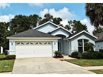 Charming one-story home featuring a well-maintained lawn, a two car garage, and nice landscaping at 2591 Oneida Loop, Kissimmee, FL 34747
