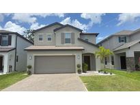 Charming two-story home with a two-car garage and a well-manicured lawn at 2833 Noble Crow Dr, Kissimmee, FL 34744