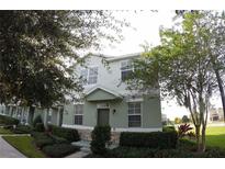 Inviting two-story home featuring a well-maintained lawn and charming architectural details at 2862 Grasmere View Pkwy, Kissimmee, FL 34746