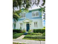 Charming two-story home boasts a landscaped yard, blue accents, and a welcoming front door with wreath at 2862 Grasmere View Pkwy, Kissimmee, FL 34746