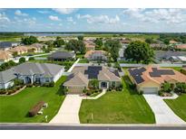 Inviting single-story home showcasing solar panels, a two-car garage, and a meticulously maintained lawn at 301 Terranova Blvd, Winter Haven, FL 33884