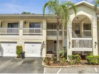 Inviting exterior of a two-story condo with palm tree, private garage, and balconies on both floors at 3205 Sabal Palms Ct # A, Kissimmee, FL 34747