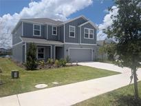 Two-story home featuring modern siding, well-kept lawn, and attached two-car garage at 5793 Gingham Dr, Kissimmee, FL 34758