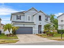 Charming two-story home with a gray exterior, well-manicured lawn, and attached two-car garage at 11603 Malverns Loop, Orlando, FL 32832
