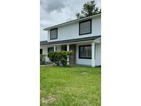 Charming two-story home with a well-maintained lawn and stylish black-framed windows at 124 Cinnamon Dr, Orlando, FL 32825