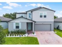 Charming two-story home with light-blue shutters, attached garage, and well-manicured lawn at 1538 Mermaid Way, Haines City, FL 33844
