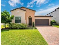 Charming one-story home with a two-car garage, beautiful landscaping, and a brick driveway at 2009 Napoli Dr, St Cloud, FL 34771