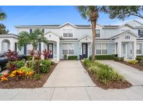 Charming townhouse with a well-maintained lawn and garden featuring palm trees and colorful shrubs at 2550 Renshaw St, Kissimmee, FL 34747