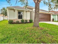 Charming home featuring a well-maintained lawn, two car garage, and mature trees at 2810 Maguire Dr, Kissimmee, FL 34741