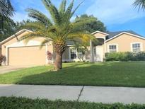 Charming single-Gathering home with a lush lawn and mature palm trees at 283 Pine Arbor Dr, Orlando, FL 32825