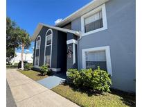 Inviting two-story condo featuring a blue exterior and well-maintained landscaping at 4160 Pershing Pointe Pl # 1, Orlando, FL 32822