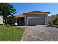 Charming single-story home featuring a red tile roof, brick driveway, and well-maintained landscaping at 455 Cinnamon Dr, Kissimmee, FL 34759