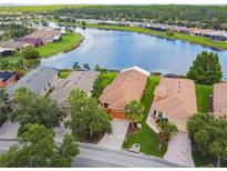 Stunning aerial view of waterfront homes with lush landscaping and serene lake views at 925 Grand Canal Dr, Poinciana, FL 34759