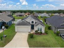 Charming single-story home with a well-manicured lawn, inviting entrance, and two-car garage in a lovely neighborhood at 973 Corvina Dr, Davenport, FL 33897