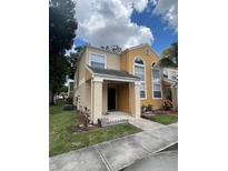 Inviting two-story townhome with a covered front porch and well-maintained lawn at 2421 Summerfield Way, Kissimmee, FL 34741
