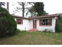 Charming single-story home featuring a well-maintained lawn and unique window details at 12019 Ne 212Th Street Rd, Fort Mc Coy, FL 32134