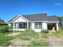 Charming single-story home featuring a modern design with an open garage and unfinished landscaping at 1236 N Virginia Ave, Lakeland, FL 33805