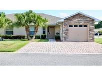 Charming home with stone accents, desert landscaping, brick paver driveway, and a two-car garage at 1749 Christina Lee Ln, St Cloud, FL 34769