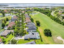 Beautiful aerial view of a home on a golf course with a pool and lake in the background at 1810 Lee Janzen Dr, Kissimmee, FL 34744
