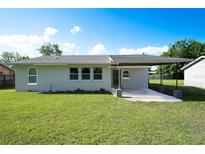 This backyard features a lush lawn and a cozy covered patio, perfect for outdoor entertaining at 2221 Wakulla Way, Orlando, FL 32839