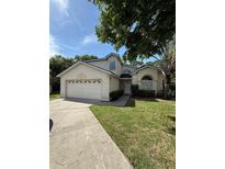Charming two-story home featuring a well-manicured lawn and attached two-car garage at 2833 Falling Tree Cir, Orlando, FL 32837